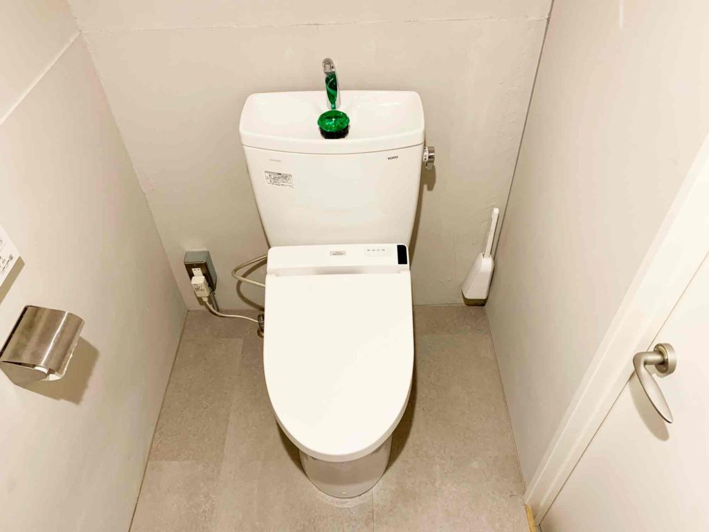 トイレブラシを壁に貼り付けて床に置かない状態になったトイレ